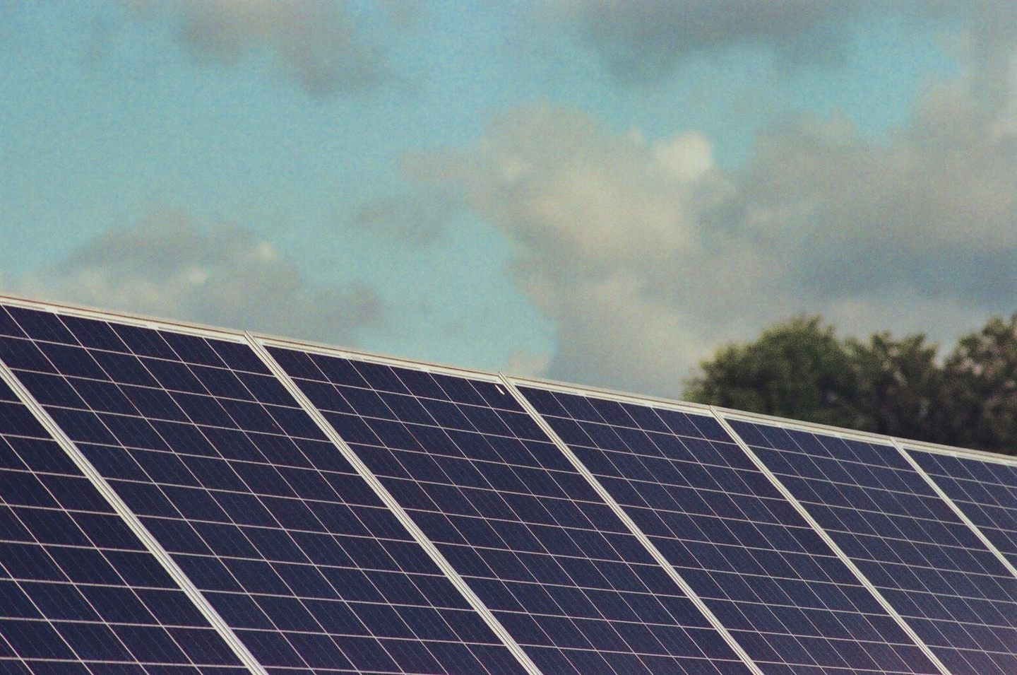 Solar panels on a roof with trees behind