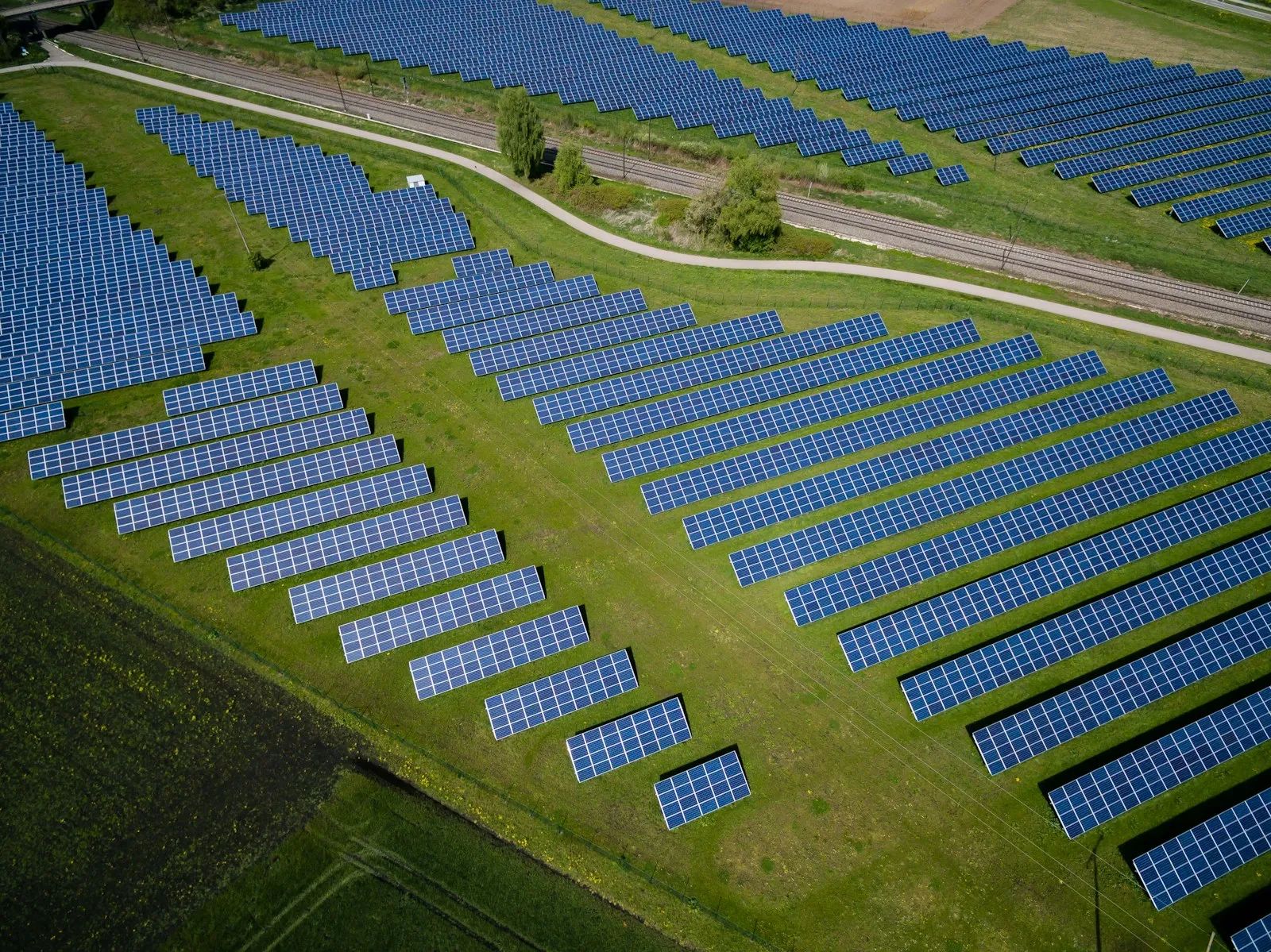Aerial view of a large solar park among green fields
